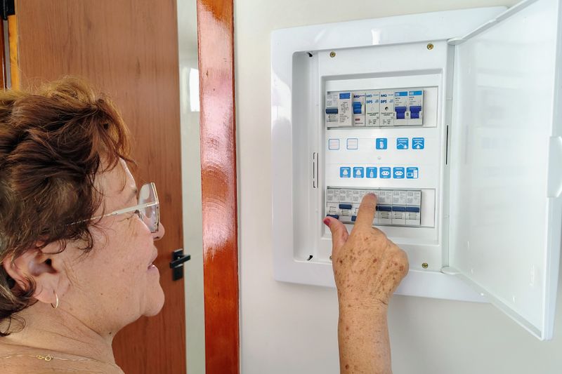 a woman checking her home's circuit breaker